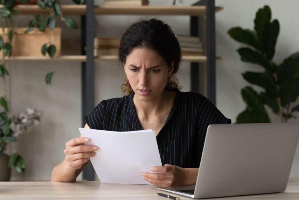 A concerned-looking woman studies a subpoena document
